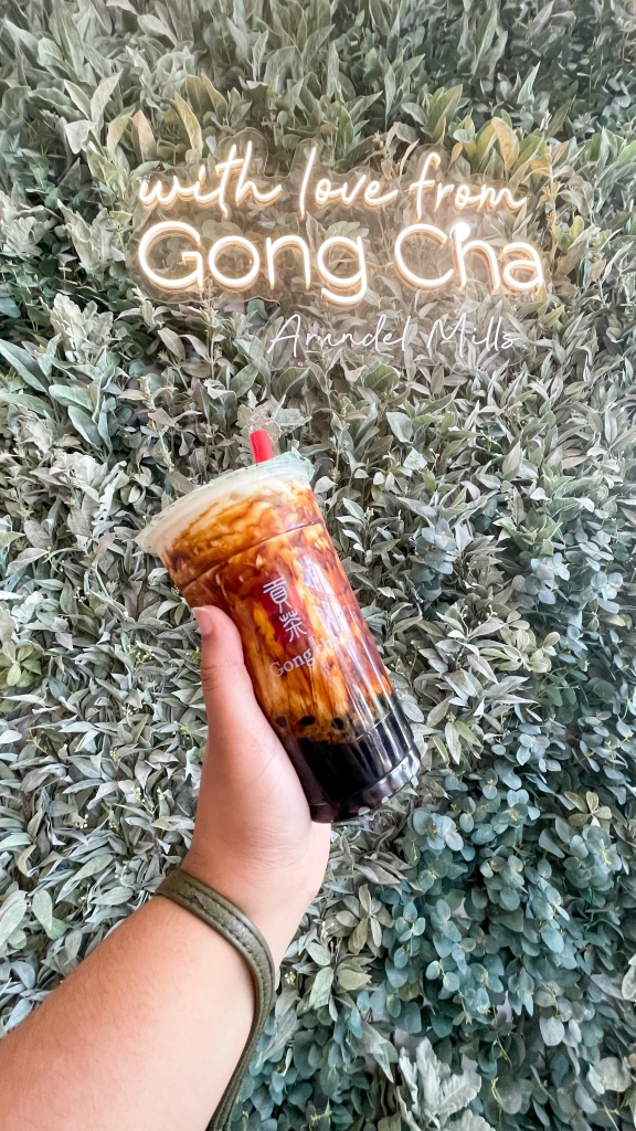 A hand holding a bubble tea latte from Gong cha. The drink is called Dirty Brown Sugar Latte.