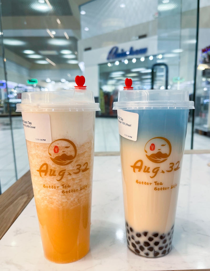 Two cups of boba tea sitting on a table