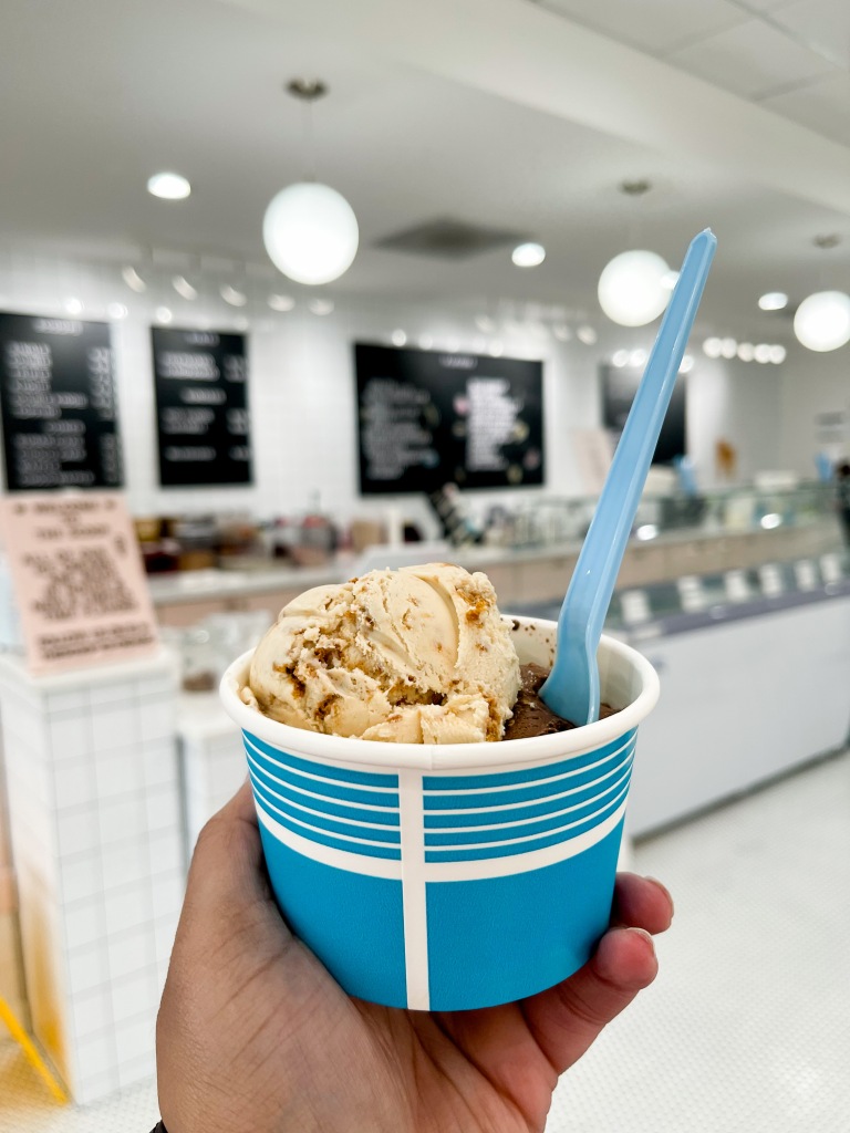 A hand holding a cup of ice cream from the Scoop, an ice cream shop in Potomac, Maryland
