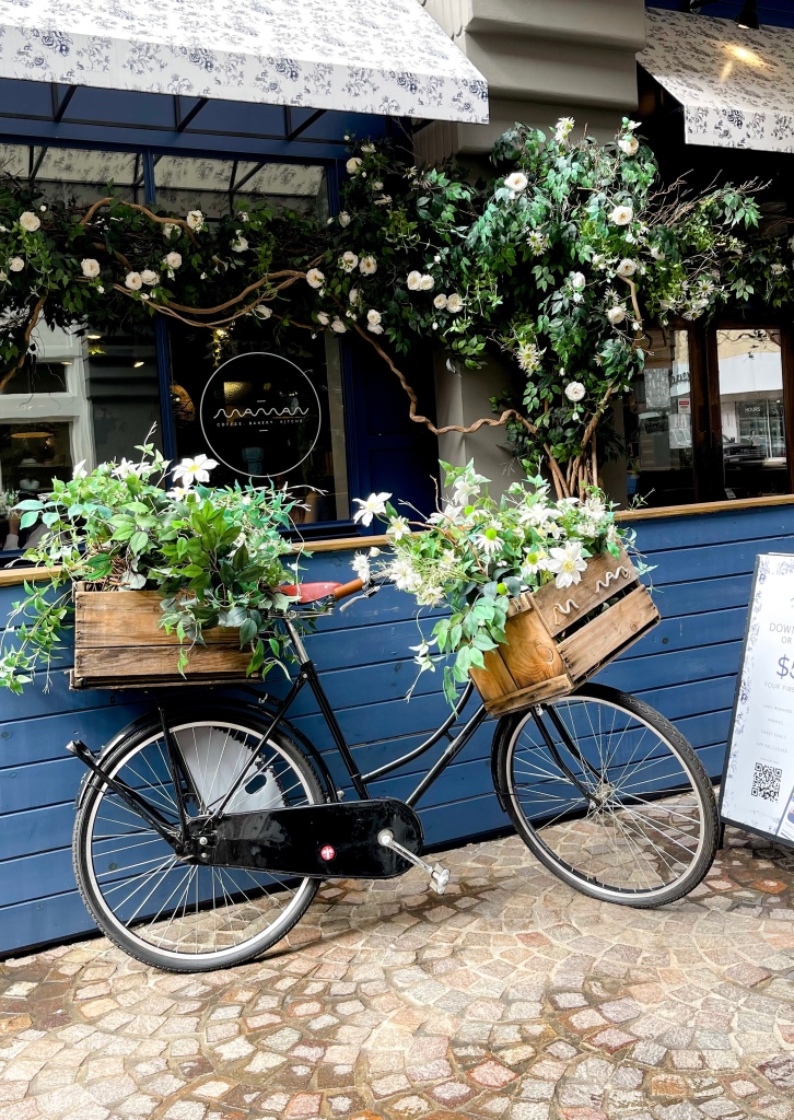 a bike decorated with flowers outside of maman, a cafe located in Bethesda, Maryland